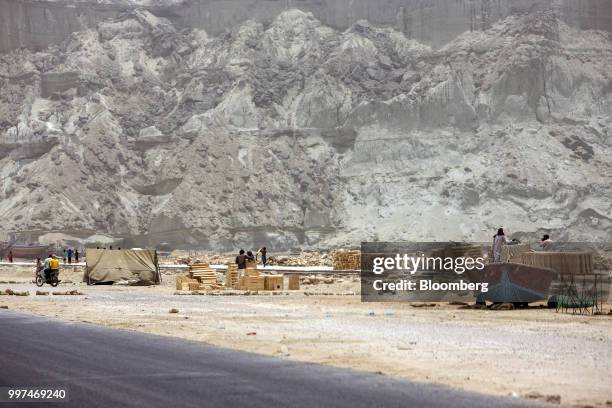 Workers construct a sidewalk on Marine Drive in Gwadar, Balochistan, Pakistan, on Tuesday, July 4, 2018. What used to be a small fishing town on the...