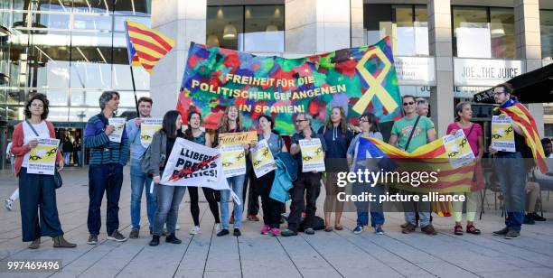 July 2018, Germany, Hamburg: Activists at the Jungfernstieg in Hamburg holding Catalonian flags and a banner with the words 'Freiheit fuer alle...