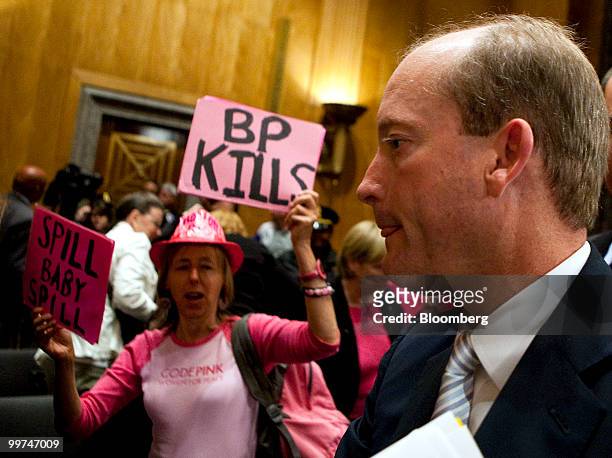 Lamar McKay, chairman of BP America Inc., right, is greeted by protesters after testifying at a Senate Homeland Security Committee hearing in...