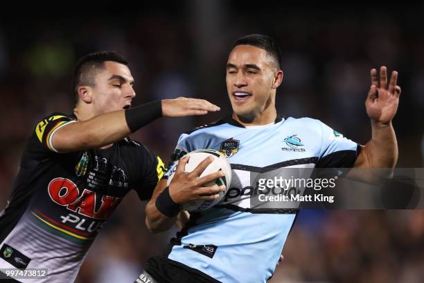 Valentine Holmes of the Sharks is tackled by Caleb Aekins of the Panthers during the round 18 NRL match between the Panthers and the Sharks at...