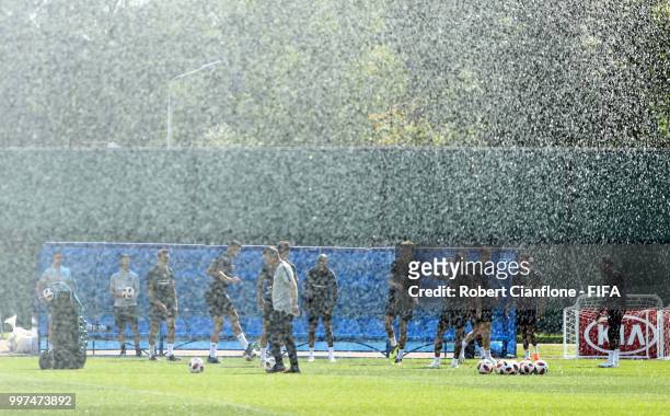 Players take part in a drill as the sprinklers spray water during an England training session during the 2018 FIFA World Cup Russia at Spartak...