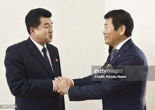 International Gymnastics Federation President Morinari Watanabe shakes hands with North Korean Sports Minister Kim Il Guk who doubles as the...