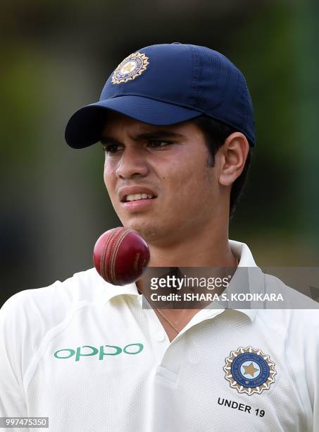 Indian under-19 cricketer Arjun Tendulkar, son of the Indian former cricket superstar Sachin Tendulkar, tosses a ball during a practice session...