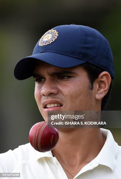 Indian under-19 cricketer Arjun Tendulkar, son of the Indian former cricket superstar Sachin Tendulkar, tosses a ball during a practice session...