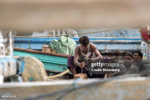 Man repairs a boat at the harbor in Gwadar, Balochistan, Pakistan, on Tuesday, July 4, 2018. What used to be a small fishing town on the southwestern...