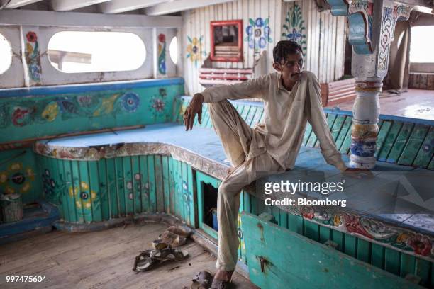 Man sits in a fishing boat moored at the fishing jetty along the port in Gwadar, Balochistan, Pakistan, on Tuesday, July 4, 2018. What used to be a...