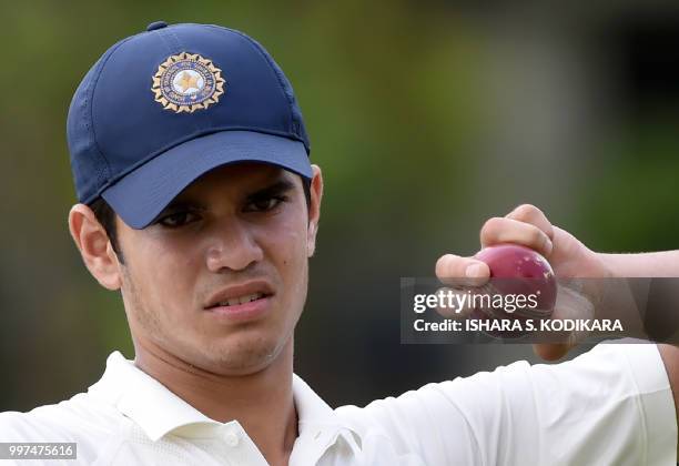 Indian under-19 cricketer Arjun Tendulkar, son of the Indian former cricket superstar Sachin Tendulkar, holds a ball during a practice session before...