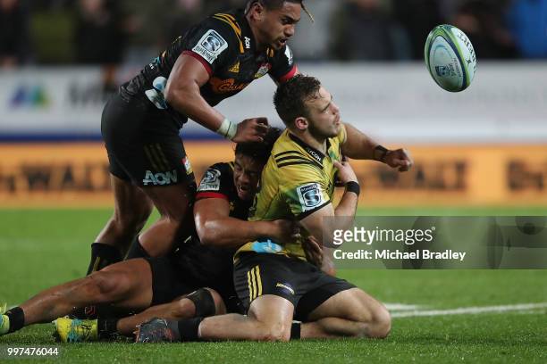 Hurricanes' Wes Goosen is tackled by Chiefs Johnny FaÕauli , who was red carrded for this tackle and Anton Lienert-Brown during the round 19 Super...