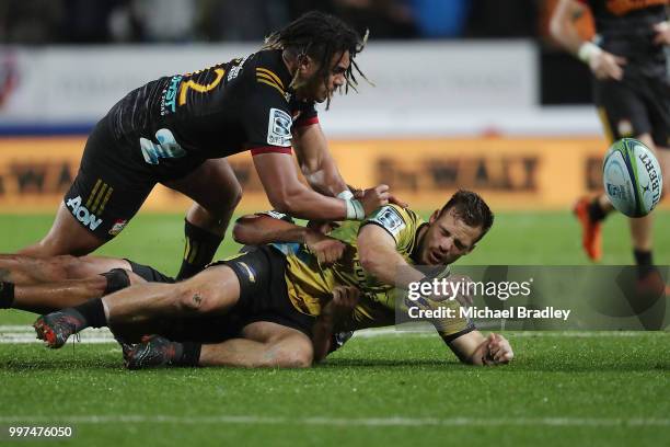 Hurricanes' Wes Goosen is tackled by Chiefs Johnny FaÕauli , who was red carrded for this tackle and Anton Lienert-Brown during the round 19 Super...