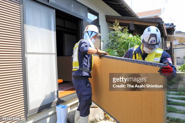 Volunteer workers take out a damaged tatami mat on July 13, 2018 in Kurume, Fukuoka, Japan. The death toll from the torrential rain in western Japan...