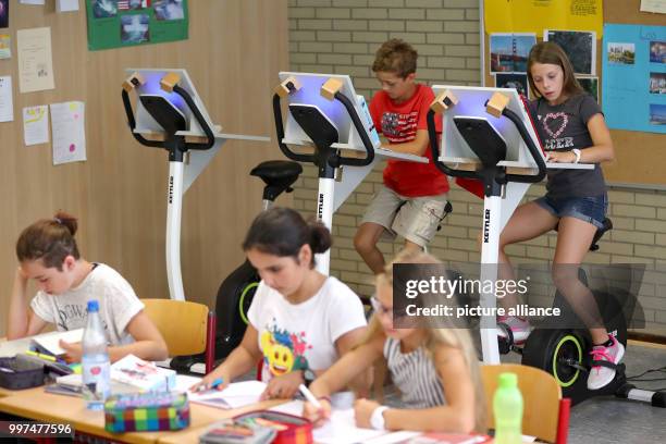 Year five pupils attend a German class while sitting on a bicycle at the Friedrich-Dessauer-Gymnasium in Aschaffenburg, Germany, 19 July 2017. The...