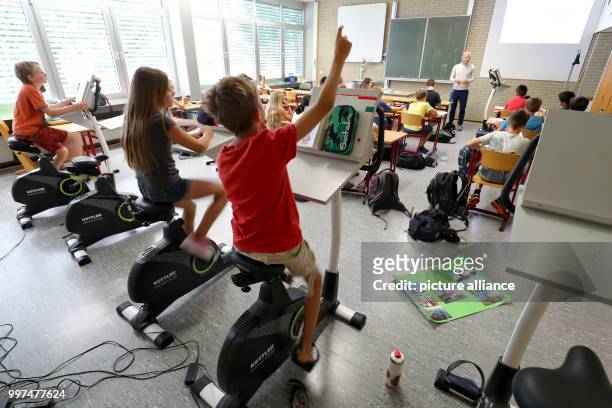 Year five pupils attend a German class while sitting on a bicycle at the Friedrich-Dessauer-Gymnasium in Aschaffenburg, Germany, 19 July 2017. The...