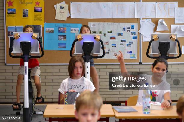 Year five pupils attend a German class while sitting on a bicycle at the Friedrich-Dessauer-Gymnasium in Aschaffenburg, Germany, 19 July 2017. The...