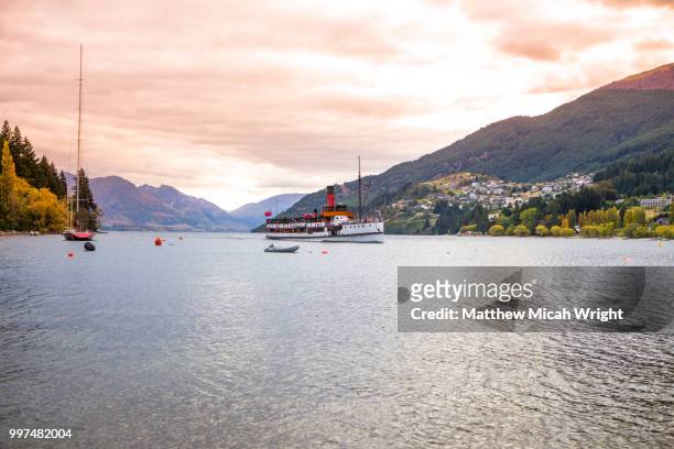the steamship tss earnslaw comes into port at sunset on lake wakatipu. - micah stock pictures, royalty-free photos & images
