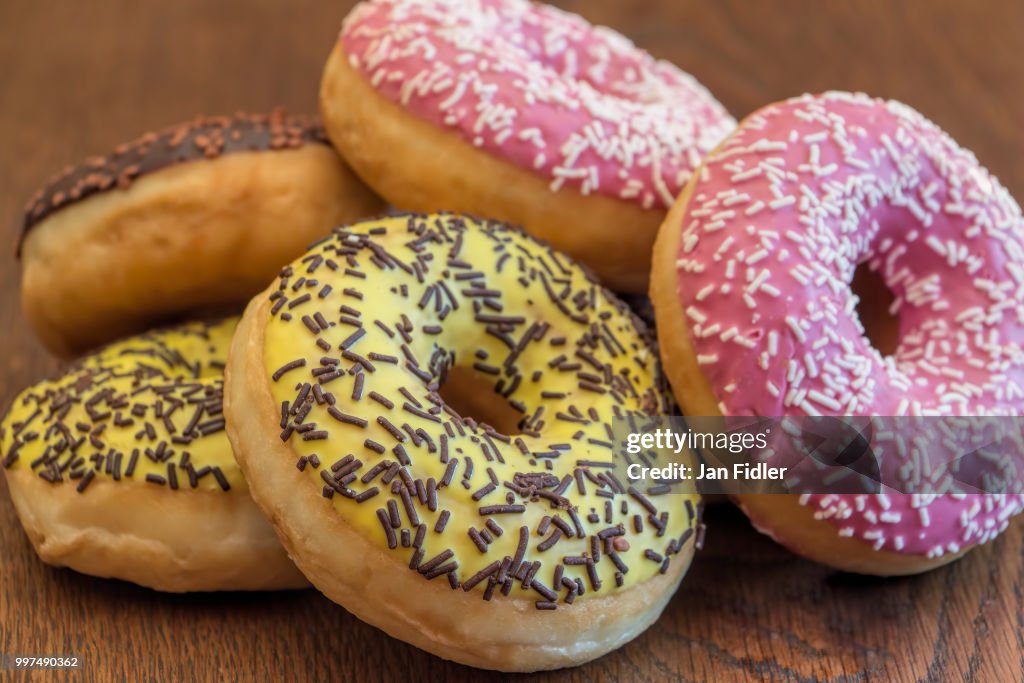 Donuts on rustic wooden table.