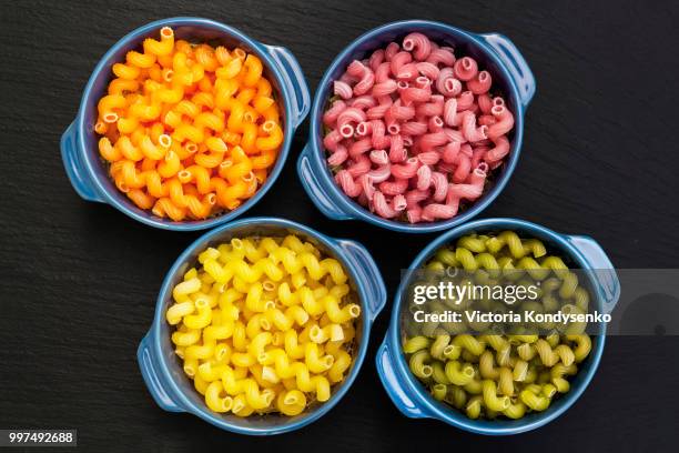 uncooked italian pasta celentani in dark blue pot - macrobiotic diet stock pictures, royalty-free photos & images