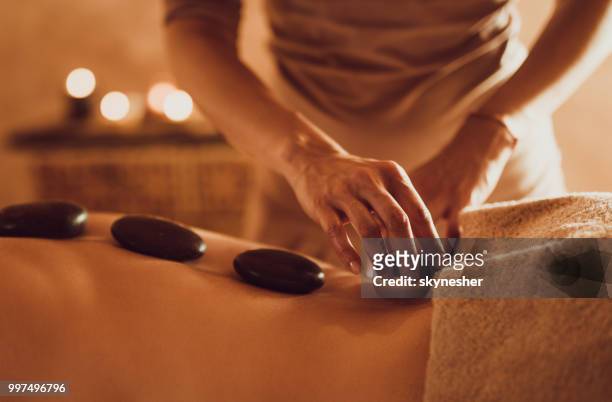 massage-therapie mit hit steinen! - skynesher stock-fotos und bilder