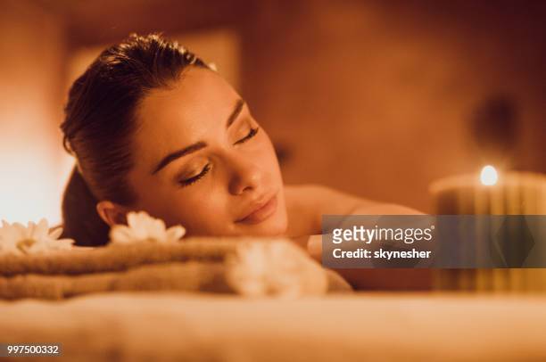 junge entspannt frau liegend auf massagetisch im spa. - skynesher stock-fotos und bilder