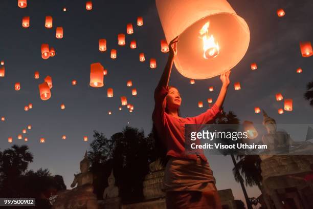women release khom loi, the sky lanterns during yi peng or loi krathong festival - tradition stock pictures, royalty-free photos & images