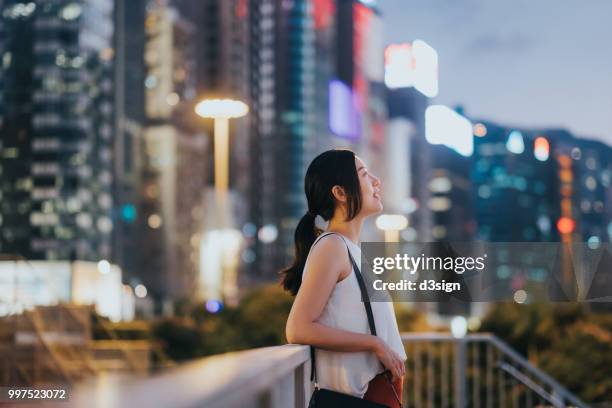 Beautiful Young Woman Resting By The Fence And Looking Up To The Sky Enjoying The Spectacular Sunset In City High-Res Stock Photo