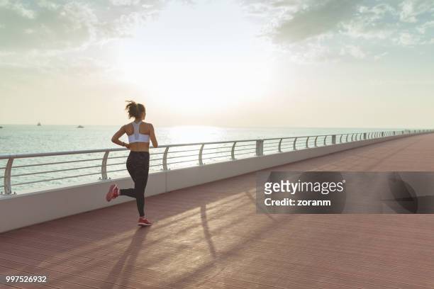 young woman jogging away - zoranm imagens e fotografias de stock