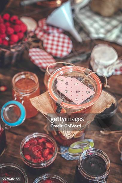 preparing homemade strawberry, blueberry and raspberry jam and canning in jars - raspberry jam stock pictures, royalty-free photos & images