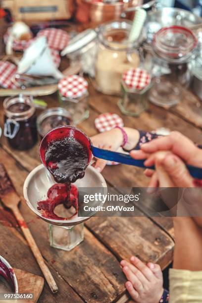 preparing homemade blueberry jam and canning in jars - raspberry jam stock pictures, royalty-free photos & images