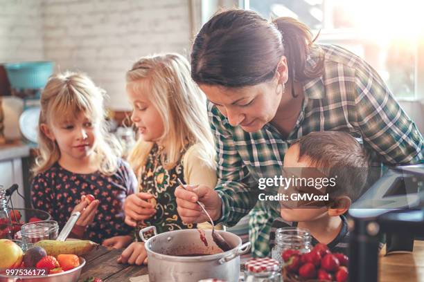 preparing homemade strawberry, blueberry and raspberry jam and canning in jars - gmvozd stock pictures, royalty-free photos & images