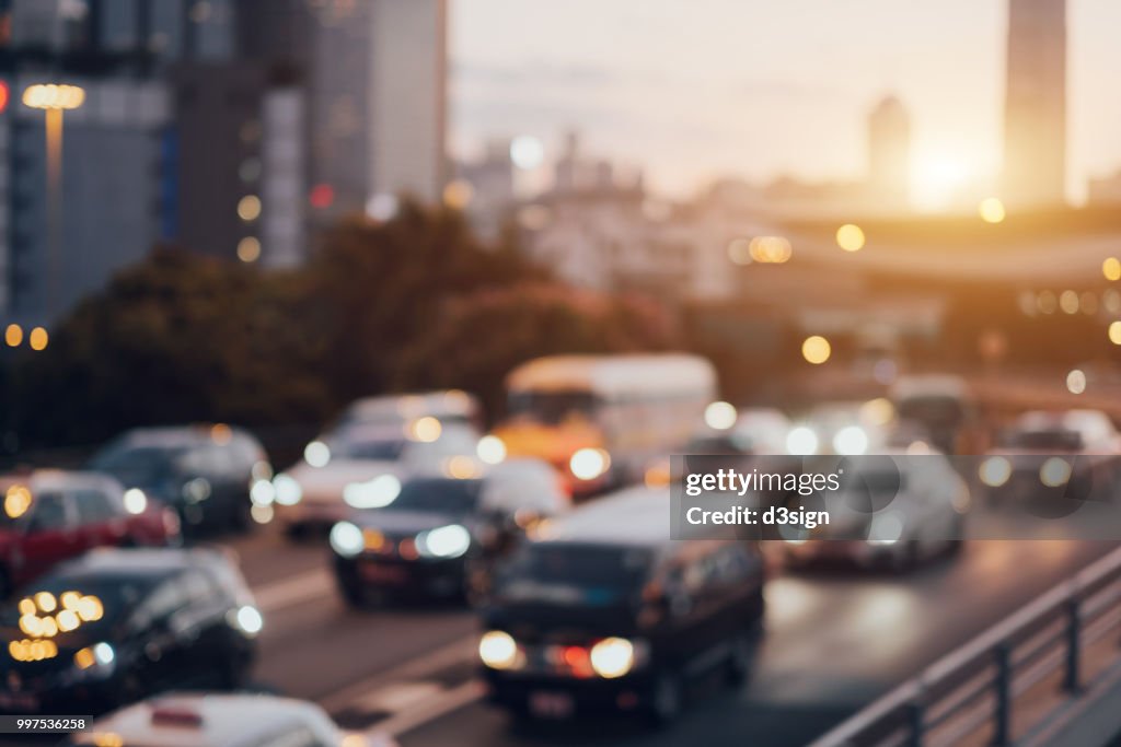 Blurry image of rush hour traffic on busy highway at sunset