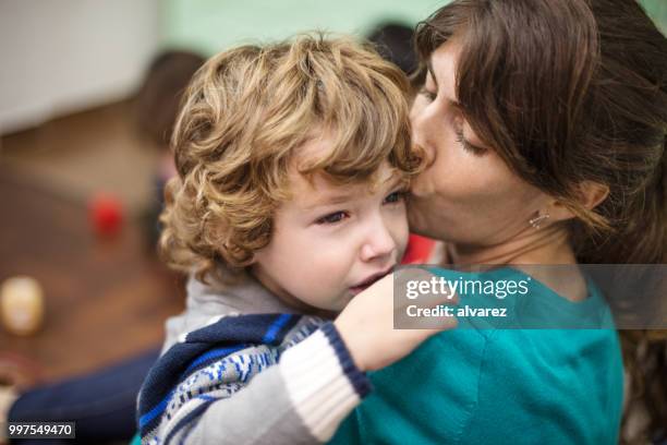 female teacher embracing crying boy - teacher crying stock pictures, royalty-free photos & images