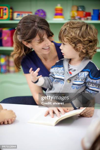 preschool student talking with teacher in classroom - narrating stock pictures, royalty-free photos & images