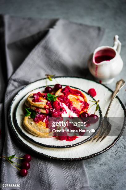 pancakes with yogurt and raspberry sauce on rustic background. - raspberry sauce stock pictures, royalty-free photos & images