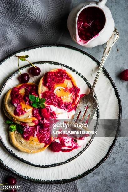 pancakes with yogurt and raspberry sauce on rustic background. - raspberry sauce stock pictures, royalty-free photos & images