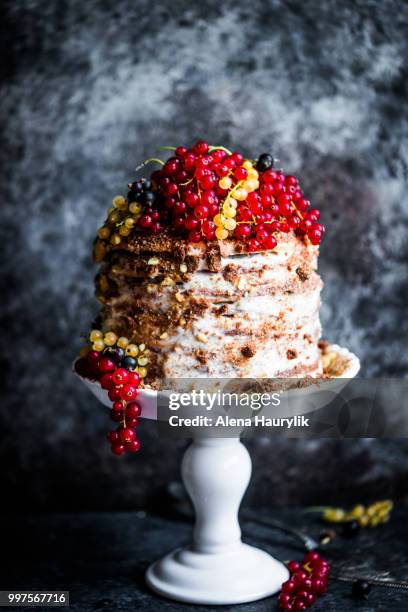 a honey cake on a cake stand, with red, white and black currants. - cake stand stockfoto's en -beelden