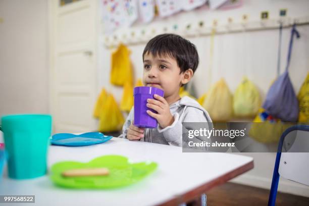 estudiante de preescolar con aperitivos en aula durante el almuerzo - niño-tomando-agua fotografías e imágenes de stock