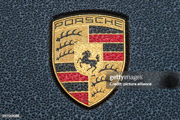 Das Wappen des Autobauers Porsche steht am in Stuttgart auf der verregneten Motorhaube eines Porsche Cayenne. Foto: Wolfram Kastl/dpa +++ dpa -...