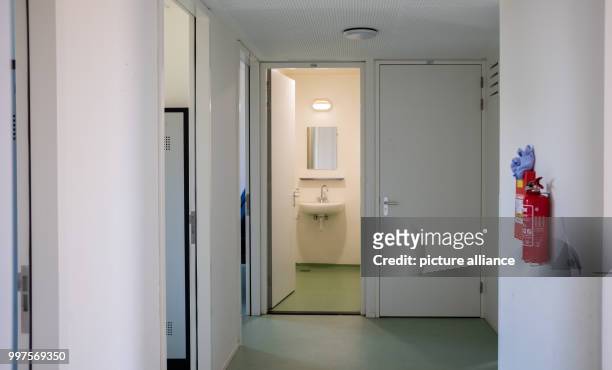 July 2018, Netherlands, Ter Apel: View through a hallway into a bathroom in unoccupied accomodation for refugees at the main reception centre for...