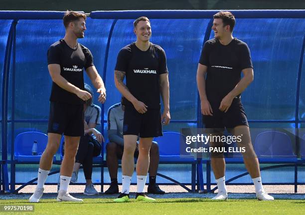 England's defenders Gary Cahill, Phil Jones and Harry Maguire laugh during a training session in Repino near Saint Petersburg on July 13, 2018 on the...