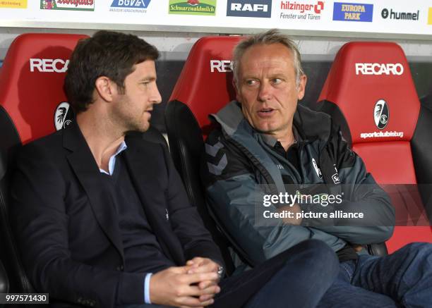 Sporting director Jochen Saier and coach Christian Streich of Freiburg watch their team warming up for the Europa League qualifier between SC...