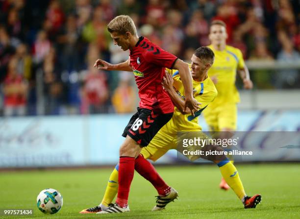 Nils Petersen of Freiburg and Lovro Bizjak of Domzale vie for the ball during the Europa League qualifier between SC Freiburg and NK Domzale at the...