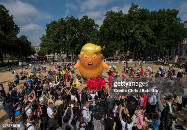 Demonstrators raise a six meter high effigy of Donald Trump, being dubbed the 'Trump Baby', in Parliament Square in protest against the U.S....