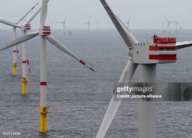 Technicians enter the lower work platform of a wind turbine of the offshore wind park "Nordsee 1" in front of the East Frisian island Spiekeroog,...