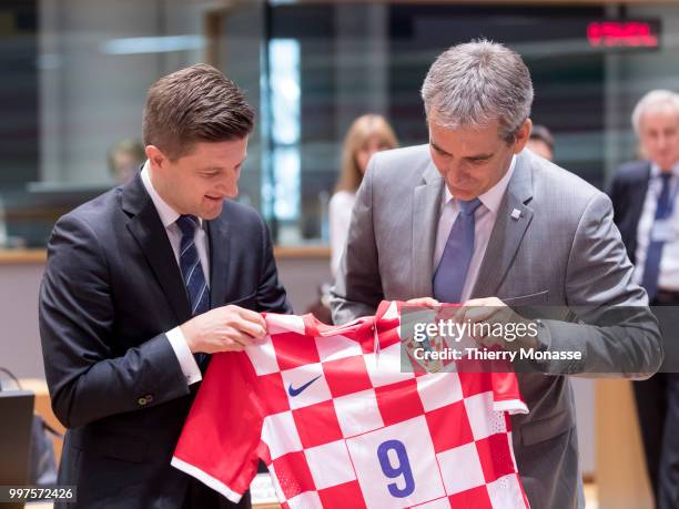 Croatian Minister of Finance Zdravko Maric is giving a Croatian Football team jersey to the Austrian Finance Minister, President of the Council...