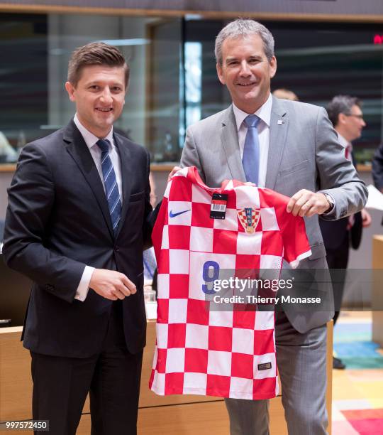 Croatian Minister of Finance Zdravko Maric is giving a Croatian Football team jersey to the Austrian Finance Minister, President of the Council...