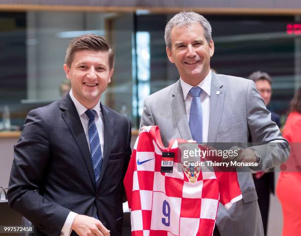 Croatian Minister of Finance Zdravko Maric is giving a Croatian Football team jersey to the Austrian Finance Minister, President of the Council...