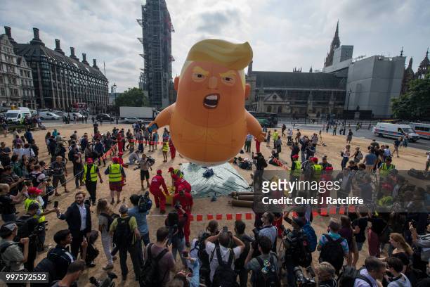 Demonstrators raise a six meter high effigy of Donald Trump, being dubbed the 'Trump Baby', in Parliament Square in protest against the U.S....