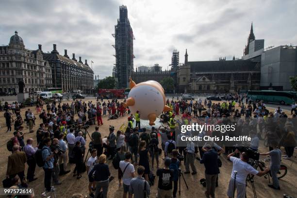 Demonstrators raise a six meter high effigy of Donald Trump, being dubbed the 'Trump Baby', in Parliament Square in protest against the U.S....