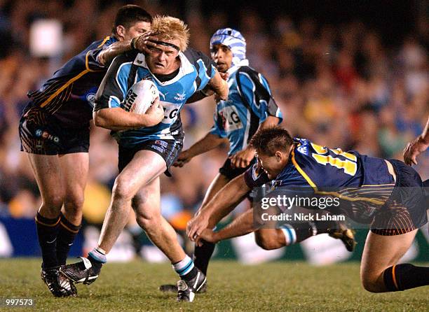 Nathan Long of the Sharks attempts to break through the defence of Luke Priddis and Dane Carlaw of the Broncos during the NRL qualifying final...