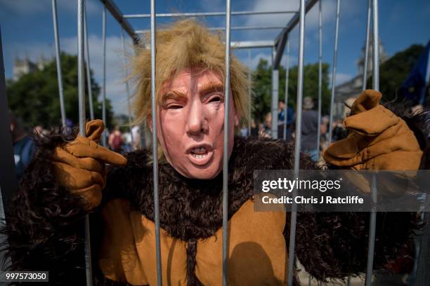 Man dressed as the U.S. President in a gorilla costume as demonstrators raise a six meter high effigy of Donald Trump, being dubbed the 'Trump Baby',...