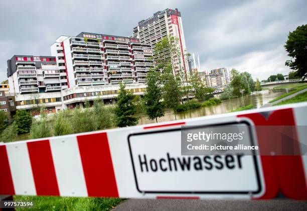 The warning sign "Flooding" can be seen on a barrier in front of the Ihme Centre in Hanover, Germany, 28 July 2017. Continuous rain has caused severe...